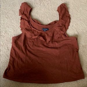 Sleeveless/tank top. Rust or port-colored.